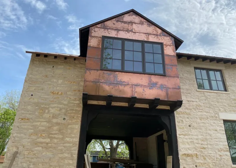 Copper metal panel facade on a stone building for Skylight Installation in Cottage Grove